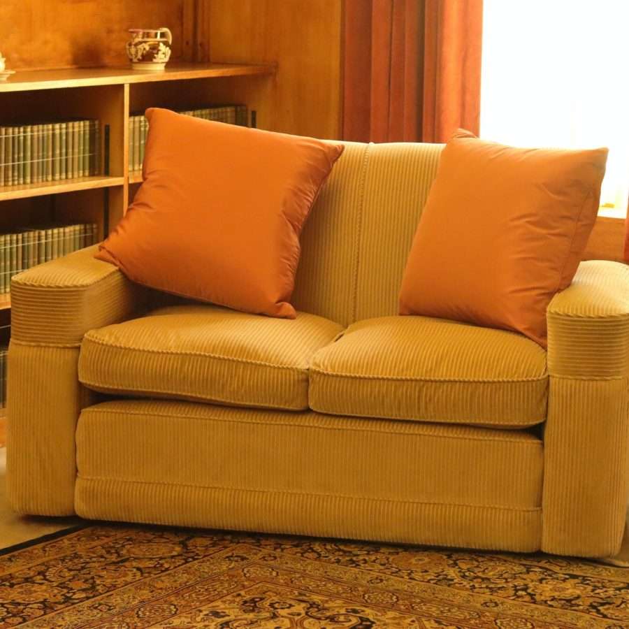 brown 2-seat sofa beside an orange curtain