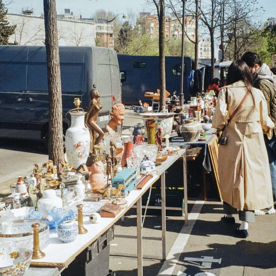  a group of people standing around a table with vases