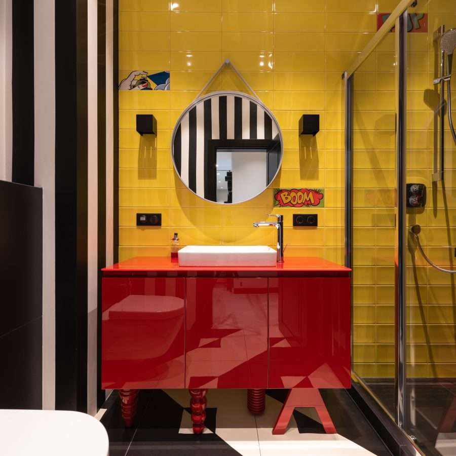 Colourful bathroom with sink on cabinet near mirror and toilet