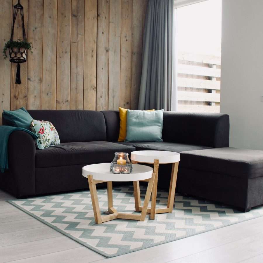  light candle on a round white coffee table and sectional sofa