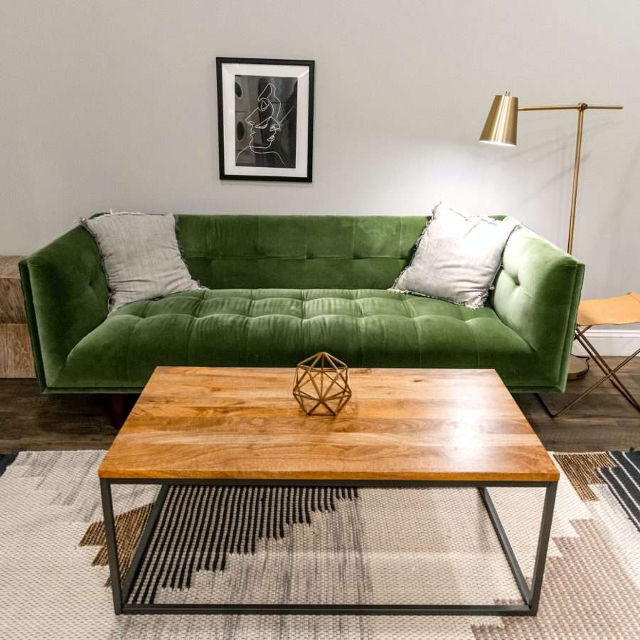 a brown wooden table near a green sofa