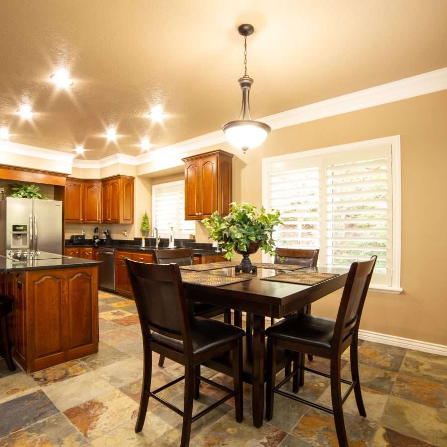a kitchen near a dining area with a pendant light