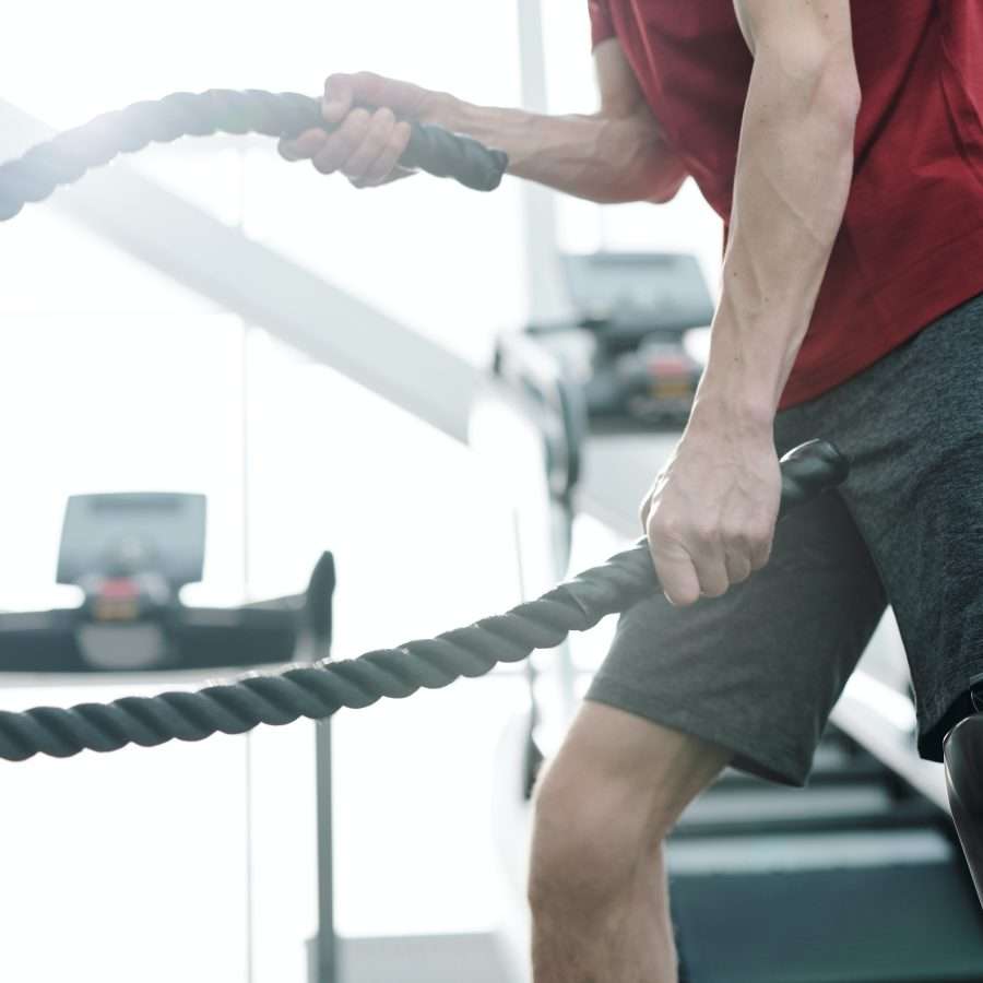  Man in Red T-shirt and Gray Shorts Holding Rope