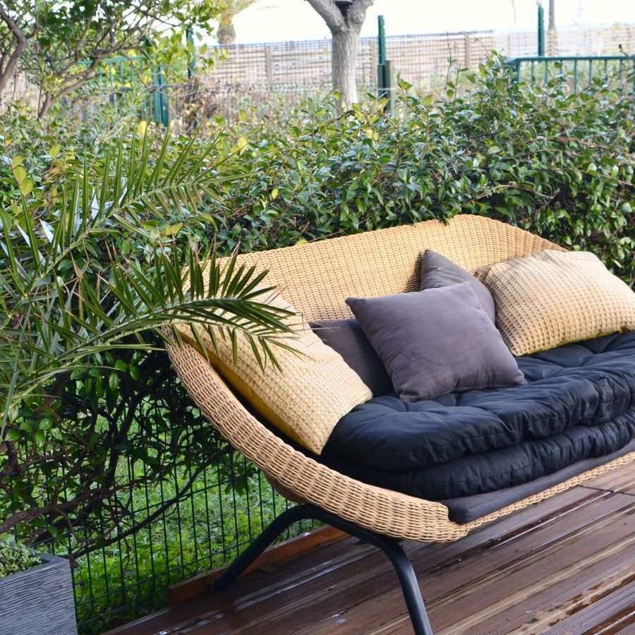 Stylish wicker sofa placed in patio