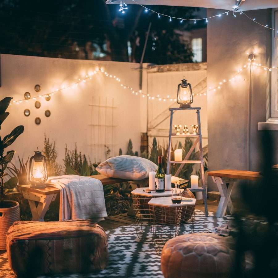 a cosy outdoor space with rugs and ambient lights